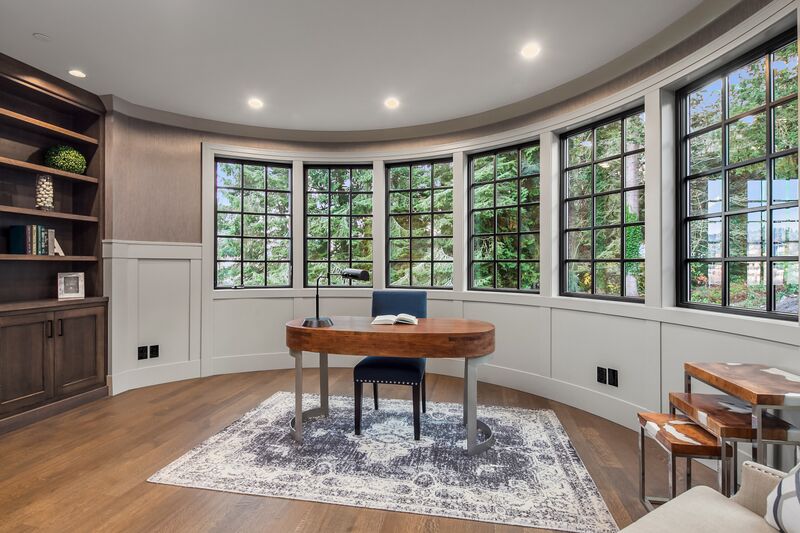 Home office in a custom-designed home featuring wrap-around windows. Designed by Seattle architects from Architectural Innovations